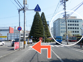 歩道橋を越えて、右側が市役所を見ながら、左へ進行します。左へ入ると、交番があります。（左へ入っても右車線を走行下さい）