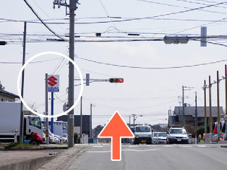 直進後、左にパチンコ店、右斜め前方に中古車店が見えます。