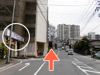 左手に市役所の「八戸市中央駐車場」が見えます。そのまま直進ください。